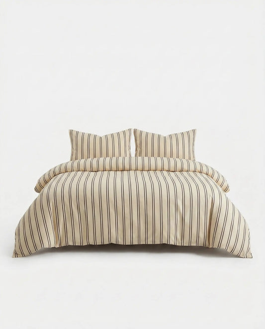 Beige striped duvet cover set displayed on white studio bed with matching pillowcases