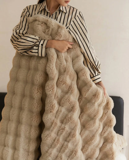 Person holding DORMÉ Studio Marshmallow Ultra Plush Blanket in khaki plush fabric showing thick sculpted texture.