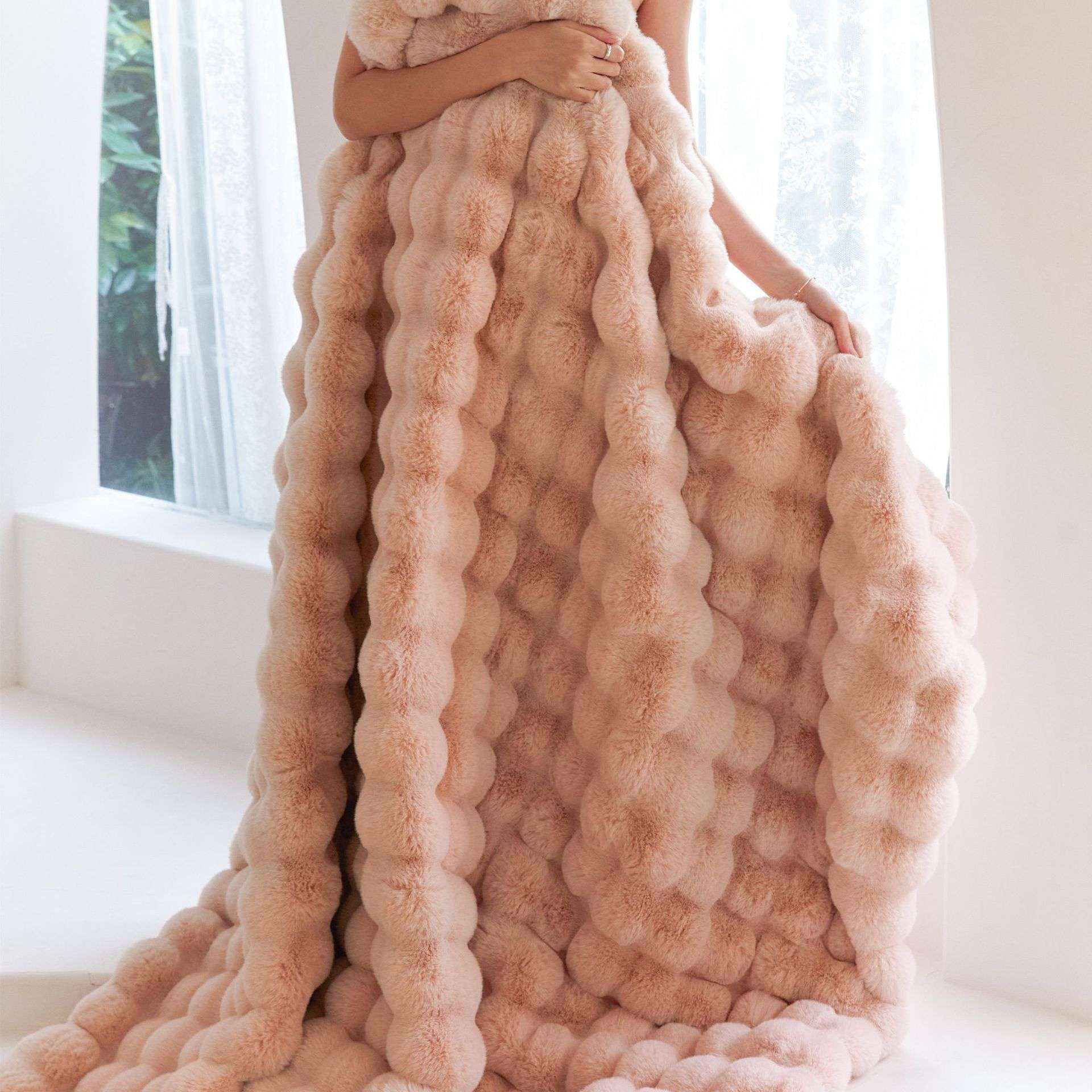 VibeCore Marshmallow Ultra Plush Blanket Blossom With Woman Cuddled In It Standing, demonstrating its size and plushness.