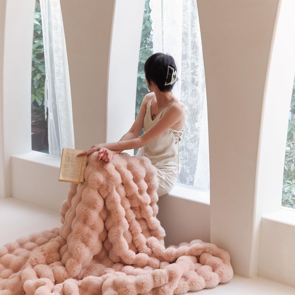 VibeCore Marshmallow Ultra Plush Blanket Blossom With Woman Cuddled In It Sitting, perfect for relaxing and getting cozy.