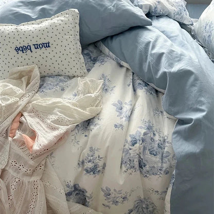 Floral bedding with a person partially visible, wearing a lace outfit.