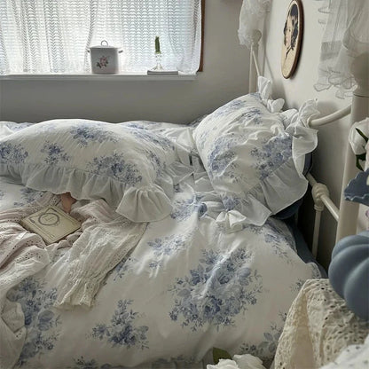Bedroom with floral bedding and lace curtains